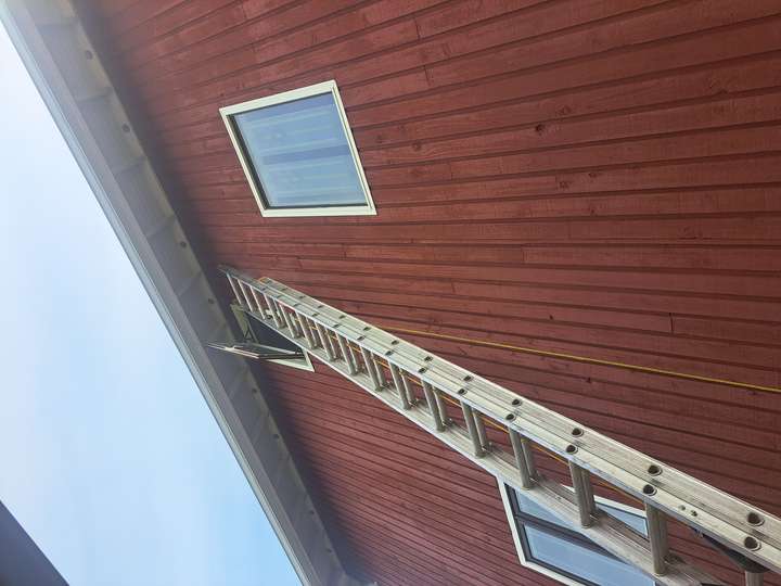Ladder to perform siding repair on old house