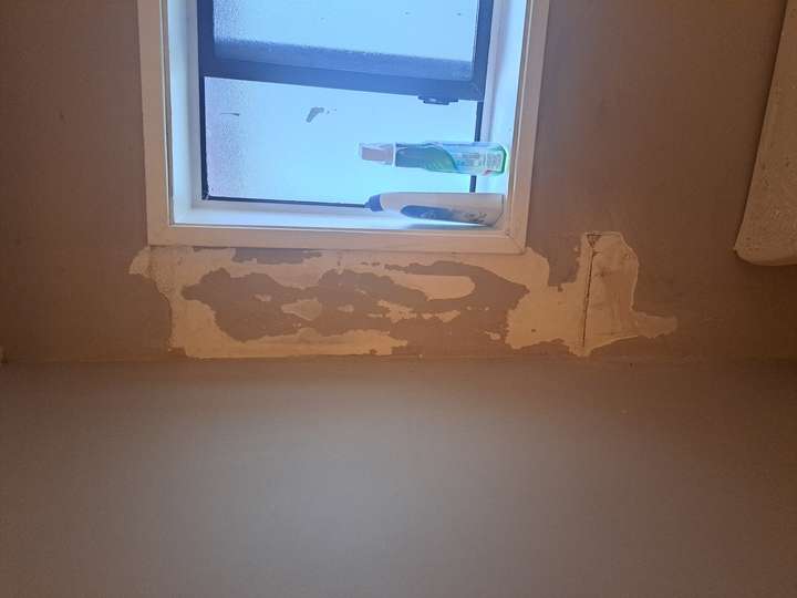 before repairing moisture damage to wall in bathroom